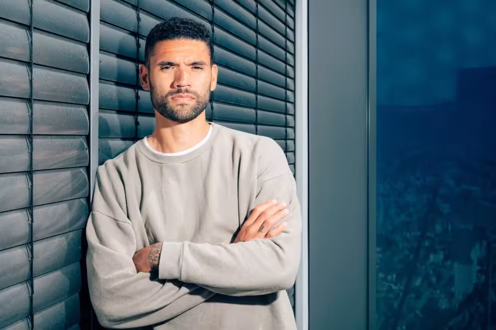 Victor Pálsson mit verschränkten Armen vor einer Fensterfront